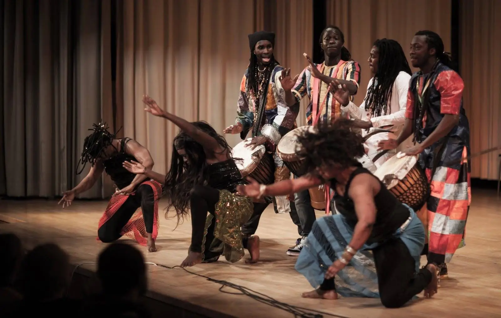 A West African dance troupe performs with drummers on stage
