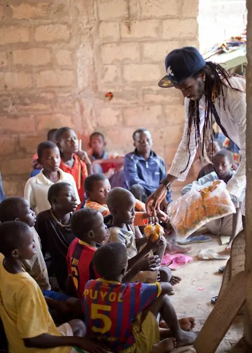 A volunteer hands out supplies to children in Senegal