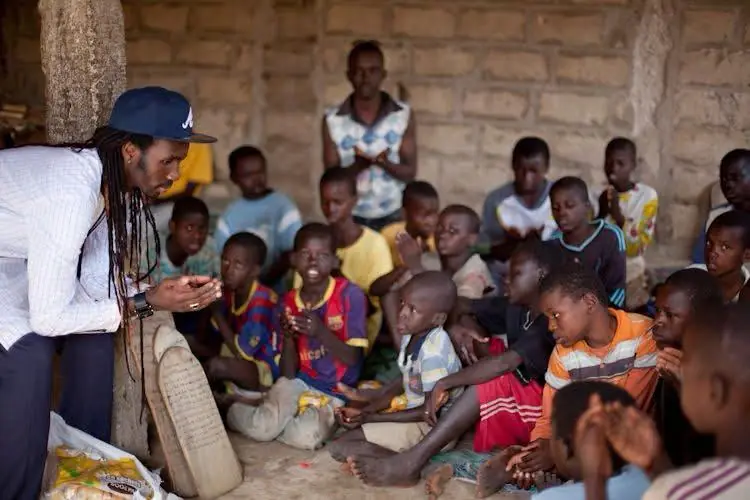 A volunteer talks with a group of children seated together in Senegal